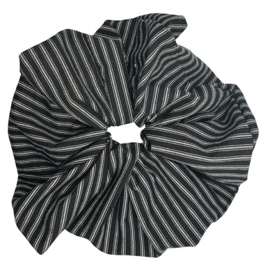 The ATHENA NEWTON Cotton Oversized Scrunchie is a statement hair accessory featuring black and white vertical stripes with a gathered, ruffled design ideal for tying back hair.