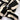 A close-up of ATHENA NEWTON's Black and White Scrunchie showcases a black and white striped pattern twisted into a knot. The cotton accessory's bold stripes create a dynamic, contrasting design against the plain white background.