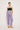 Against a white background, a person wears ATHENA NEWTON's Lilac Linen Pants, characterized by their high-waisted relaxed fit. The black strapless top complements the easy style of breathable lilac fabric paired perfectly with beige sandals. Hands rest casually in the pockets.
.